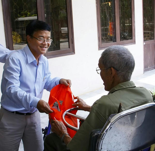 Nhà báo Huỳnh Dũng Nhân tặng quà cho một bác thương binh nhân 70 năm ngày thành lập quân đội nhân dân Việt Nam